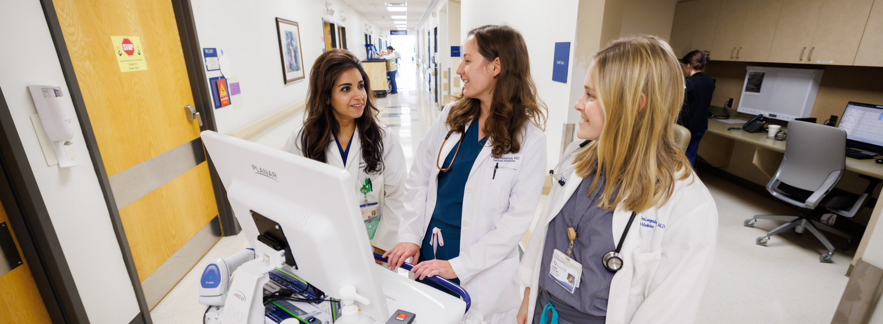 Three hospitalists interact while charting a patient encounter. Three hospitalists interact while charting a patient encounter.
